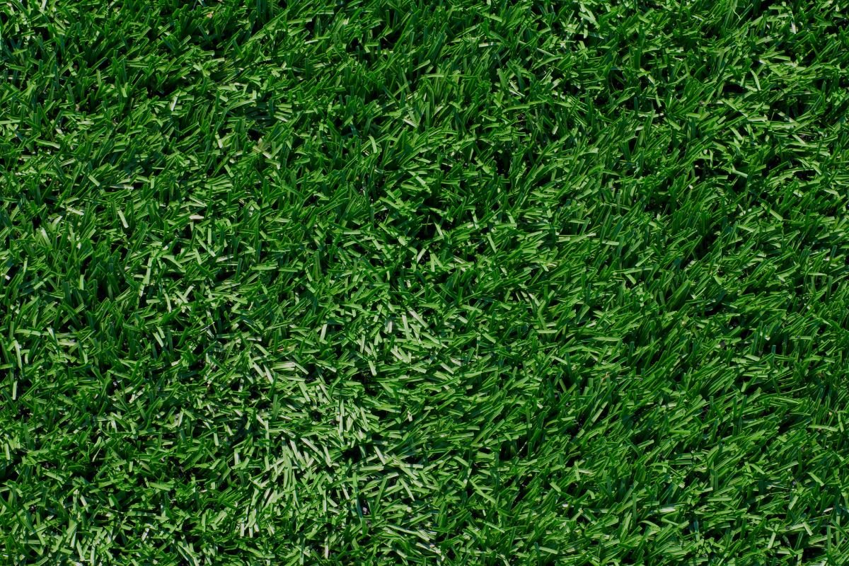  Detailed view of artificial turf texture, featuring lush green blades that mimic natural grass for outdoor aesthetics.