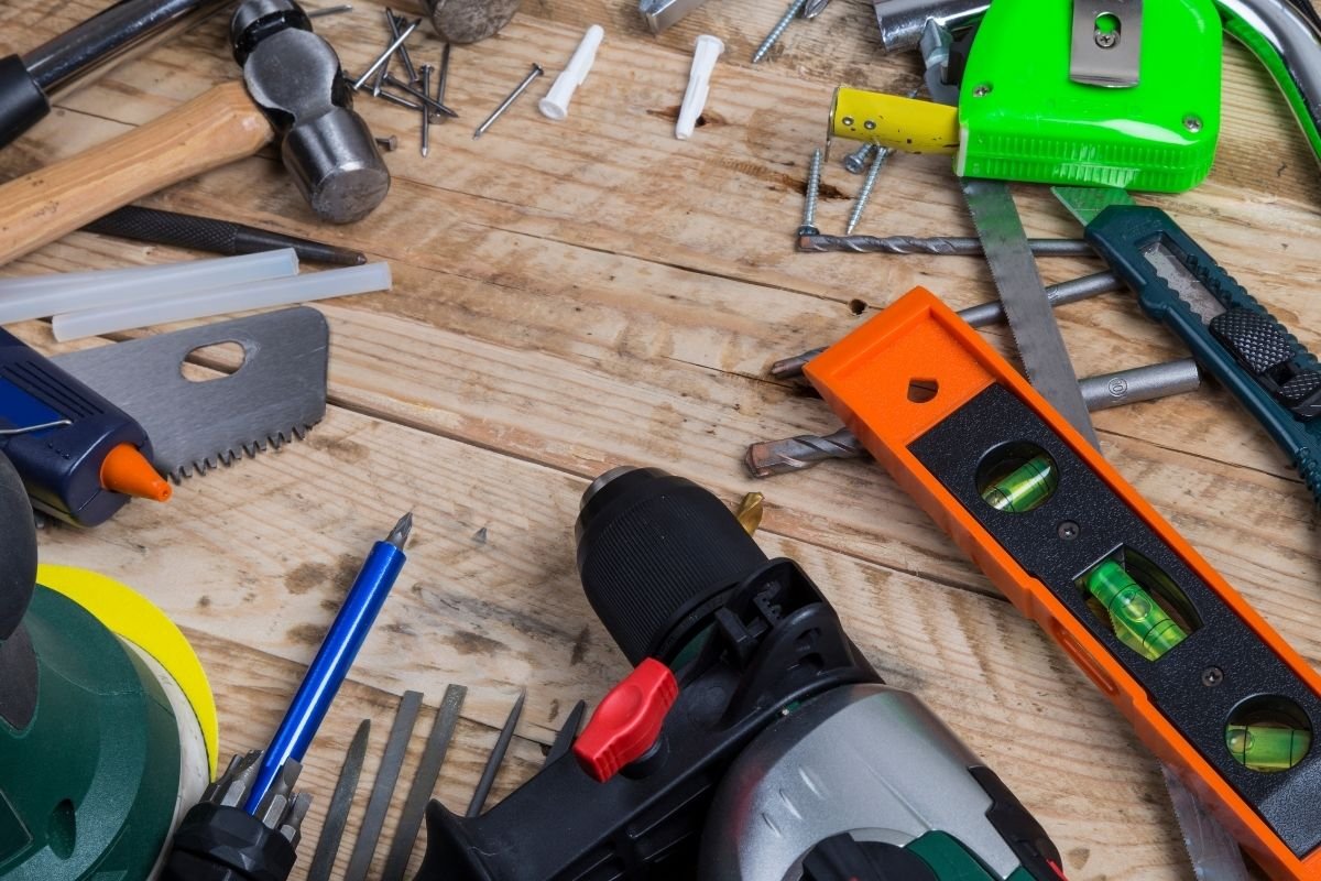 A wooden table displaying an assortment of tools, including hammers, wrenches, and screwdrivers, arranged neatly.